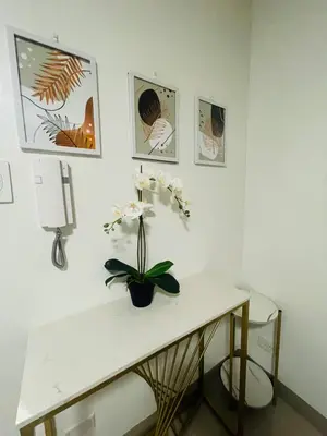 a white table with a vase of flowers on it at Shore 2 Residences Moa Pasay in Manila