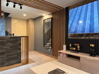 a living room with a large window and a tv at 2 bedroom loft type near Rockwell in Manila