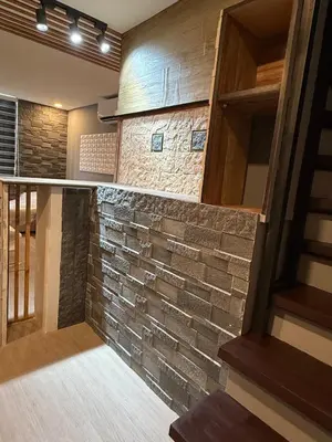 a brick wall in a room with a staircase at 2 bedroom loft type near Rockwell in Manila