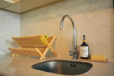 a kitchen counter with a sink and a bottle of wine at Upscale Stylish Suite Near BGC and View of Venice Grand Canal Mall in Manila