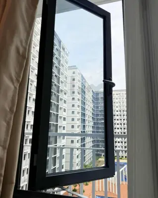 a window with a view of a tall building at Lilom in Manila