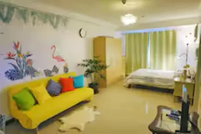 a living room with a yellow couch and a bed at 5 mins SM Aura Cozy Studio Type in Manila