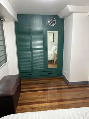 a room with a green wall with a couch in it at Simple but cozy, feel at home in Manila