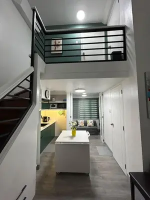 a kitchen and living room in a house with a staircase at Simple but cozy, feel at home in Manila
