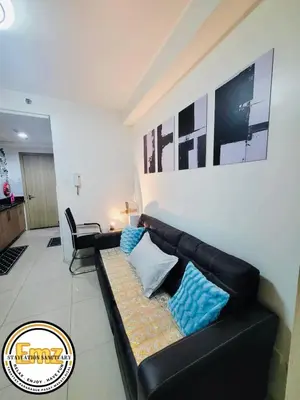 a black leather couch sitting in a living room at EMZ Shore Staycation 38 in Manila