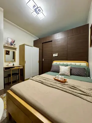a bedroom with a large bed with a tray on it at The Scandi Hub at Air Residences, Makati in Manila