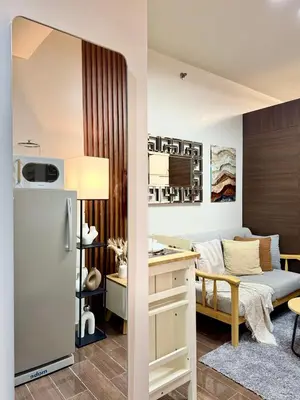 a kitchen and a living room with a refrigerator at The Scandi Hub at Air Residences, Makati in Manila