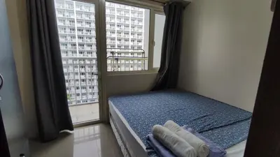 a bedroom with a bed and a large window at Shore Residences - 1BR Breezy Home Near the Sea in Manila