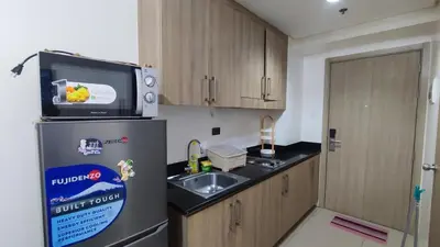 a small kitchen with a sink and a refrigerator at Shore Residences - 1BR Breezy Home Near the Sea in Manila