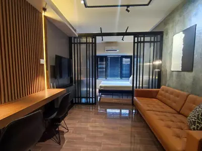 a living room with a couch and a bedroom at The Auberge at Air Residences Makati! in Manila