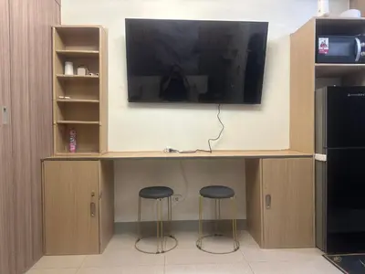 a desk with two stools under a tv at Azhyuri staycation in Manila