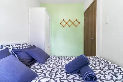 a bedroom with a bed with blue pillows on it at 1BR Staycation at S Residences Tower 1 in Manila