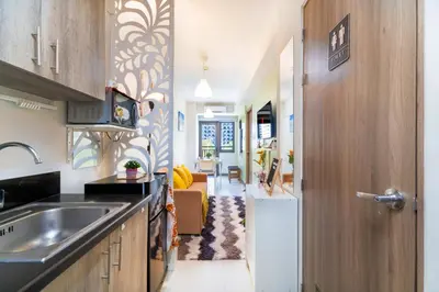 a kitchen with a sink and a door to a living room at 1BR Staycation at S Residences Tower 1 in Manila