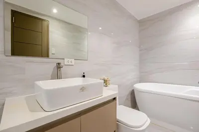 a white bathroom with a sink and a toilet at Huge 101-SQM 2BR in Central BGC Up to 12 Guests in Manila