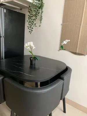 a black table with a vase with flowers on it at LEAF RESIDENCES MUNTINLUPA - M&G Staycation in Manila