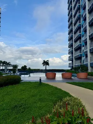 a walkway next to a large building with a palm tree at Panoramic Seaview near Airport Facing the Bay 14H in Manila