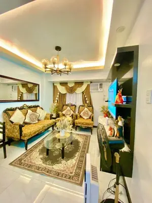 a living room with two couches and a table at Avida Towers San Lazaro in Manila