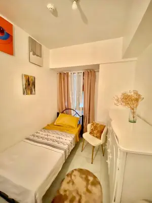a small bedroom with a bed and a desk at Avida Towers San Lazaro in Manila