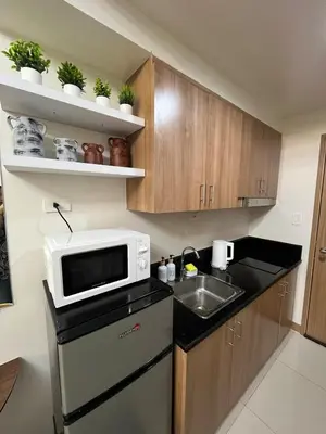 a small kitchen with a microwave and a sink at Chino Roces Makati - No Parking - Red Residences in Manila
