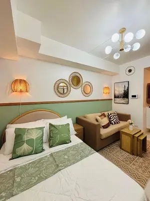 a hotel room with two beds and a couch at Grand View Tower - Metro Stay in Manila