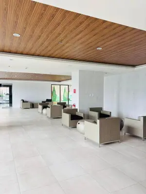 a lobby with couches and tables and a wooden ceiling at Grand View Tower - Metro Stay in Manila