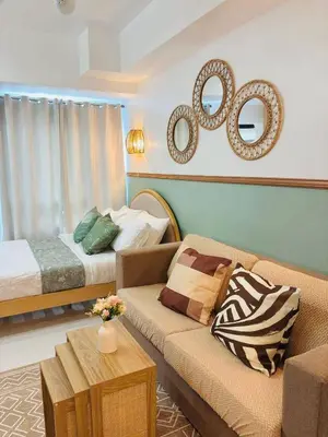 a living room with a couch and a bed at Grand View Tower - Metro Stay in Manila