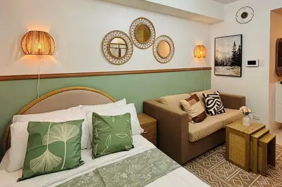 a living room with a bed and a couch at Grand View Tower - Metro Stay in Manila