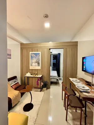 a living room with a bed and a desk at Your Skyline Hideaway in Manila