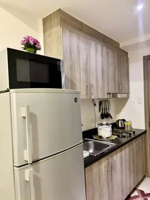 a kitchen with a refrigerator and a sink at Your Skyline Hideaway in Manila