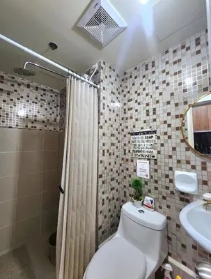 a bathroom with a toilet and a sink and a shower at Avida Towers Sucat in Manila