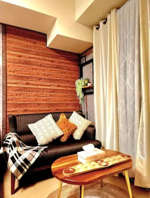 a living room with a leather couch and a coffee table at Avida Towers Sucat in Manila