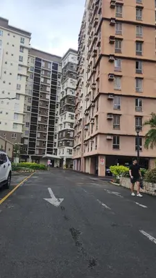 a person standing on a street in front of a building at Avida Towers Sucat in Manila