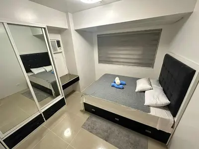a small bedroom with a blue teddy bear sitting on a bed at Family room Staycation Near MOA in Manila