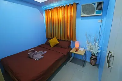 a bedroom with a bed and a table with a window at A Comfy Self-Check-In and Check-out 1BR Light Residences in Manila
