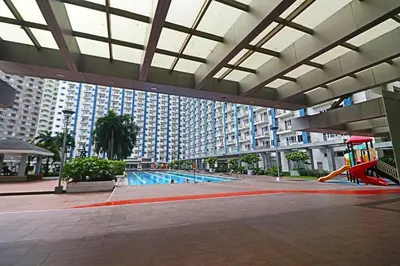 a large building with a pool and a playground at A Comfy Self-Check-In and Check-out 1BR Light Residences in Manila
