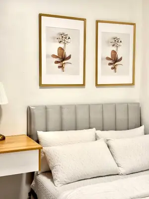two framed pictures on a wall above a couch at The Haven Suite Shore3 Residences T2 in Manila