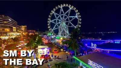 a large ferris wheel in a city at night at Sybay suites near okada MOA airport NAIA COD Manila MSV1806H in Manila