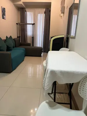 a living room with a table and a couch at 1 bedroom condo unit near MOA in Manila