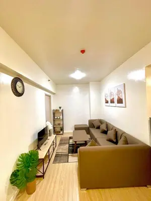 a living room with a couch and a tv at Cityscape Stays in Manila