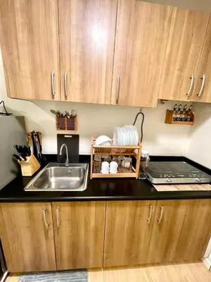 a kitchen with a sink and a counter top at Cityscape Stays in Manila