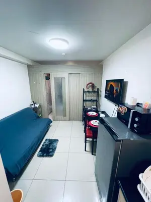 a small room with a kitchen and a bed and a table at Minimalist Flat Retreat- Shore Residences in Manila