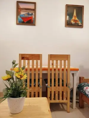 a dining room table with two chairs and a vase with yellow flowers at Green 2 Residences Tower1 unit 512 in Dasmariñas