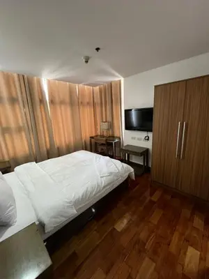 a bedroom with a bed and a flat screen tv at Antel Spa Residences 9A in Manila
