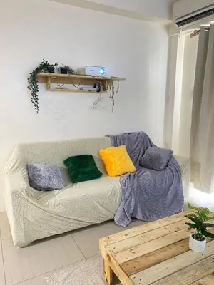 a living room with a couch with colorful pillows at Cozy Room in Modern Paraaque Condo with 2 Bedrooms in Manila