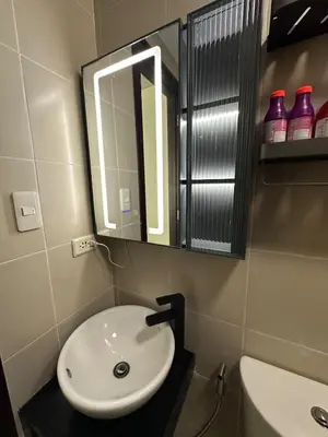 a bathroom with a white sink and a mirror at 2BR Condo in Makati- Good for 6! in Manila