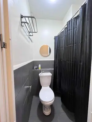 a bathroom with a toilet and a black shower at Loft life Staycation in Manila