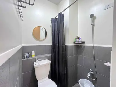 a bathroom with a shower with a toilet and a sink at Loft life Staycation in Manila