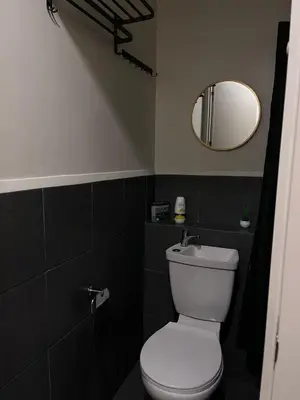 a bathroom with a white toilet and a mirror at Loft life Staycation in Manila