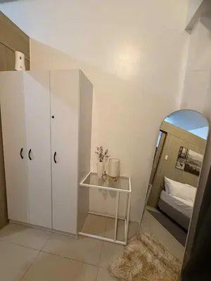a bedroom with a mirror and a bed and a table at Shore Residences 1BR Staycation in Manila