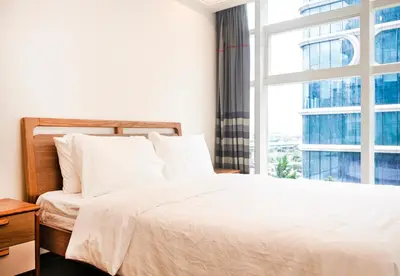 a bedroom with a white bed and a window at Grand Marina Residences in Manila